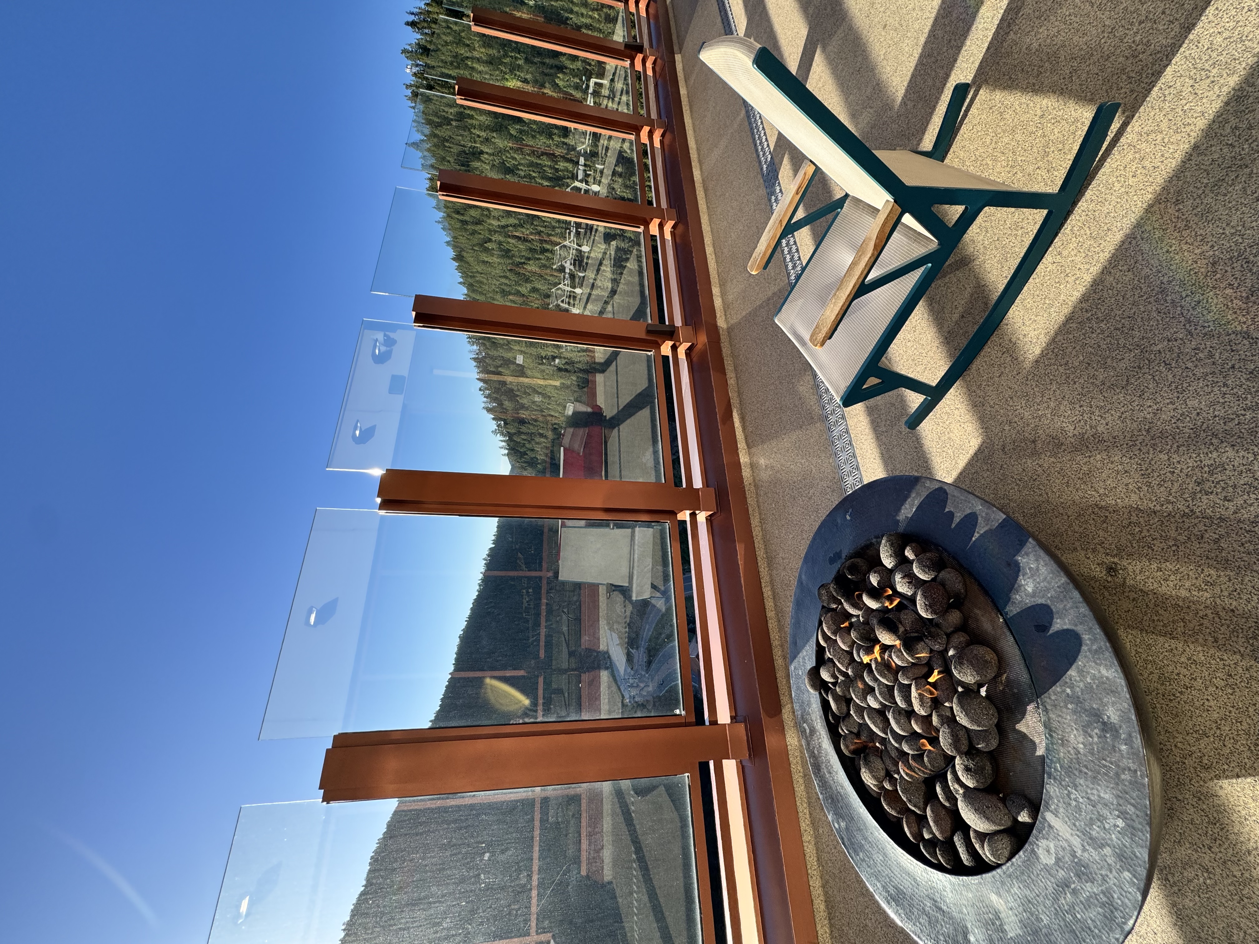 Quiet mountain overlook with a rocking chair and fire pit beneath a clear Colorado sky, inviting a moment of reflection and intentional thought.